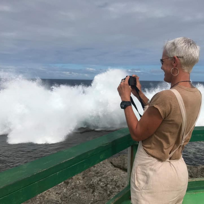 Person taking a photo of crashing waves at the beach